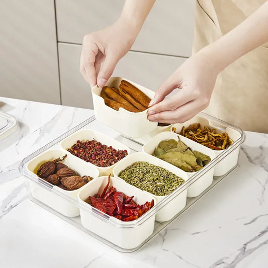 Multi-compartment serving tray filled with various dried spices and ingredients, featuring removable sections and a clear lid for organized storage.